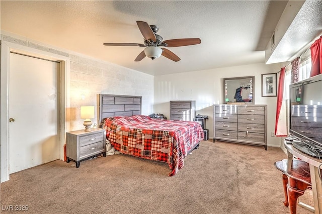 bedroom featuring ceiling fan, light colored carpet, and a textured ceiling