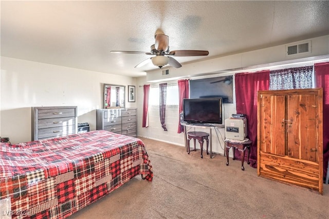 bedroom with ceiling fan, light colored carpet, and a textured ceiling