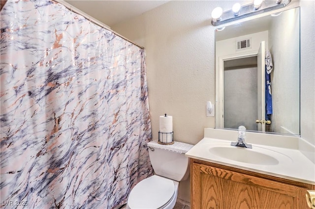 bathroom featuring vanity, toilet, and a shower with shower curtain