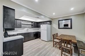 kitchen featuring crown molding, white fridge, sink, and light hardwood / wood-style floors