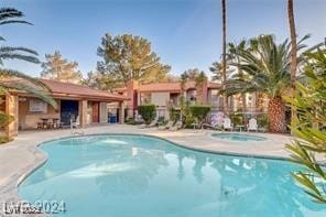 view of pool with a hot tub