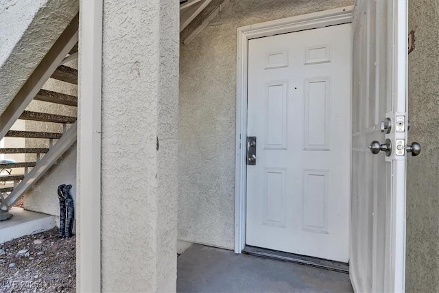 doorway to property featuring stucco siding