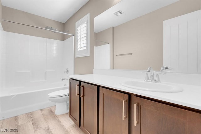 full bathroom featuring hardwood / wood-style flooring, vanity, bathtub / shower combination, and toilet