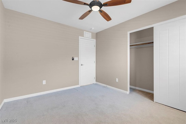 unfurnished bedroom with ceiling fan, light colored carpet, vaulted ceiling, and a closet