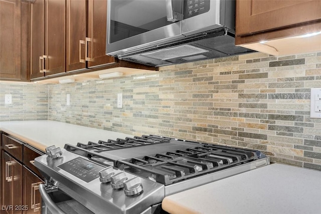 kitchen with tasteful backsplash and appliances with stainless steel finishes