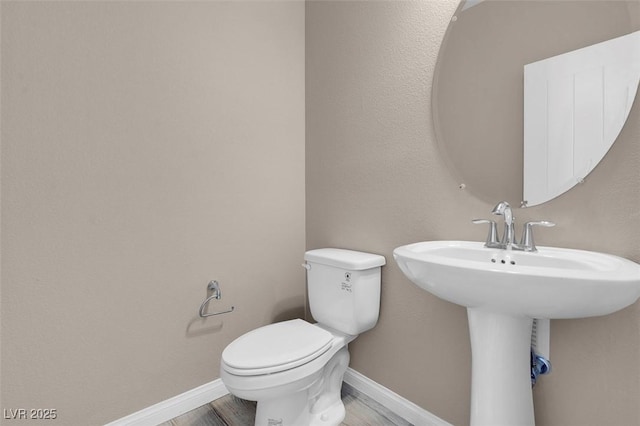 bathroom featuring wood-type flooring and toilet