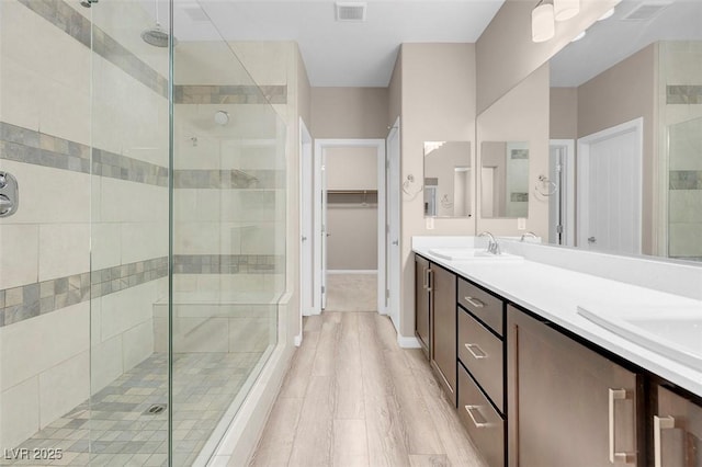 bathroom featuring vanity, a shower with shower door, and wood-type flooring