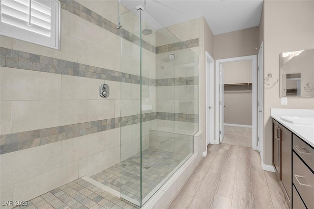 bathroom with hardwood / wood-style flooring, vanity, and a shower with door