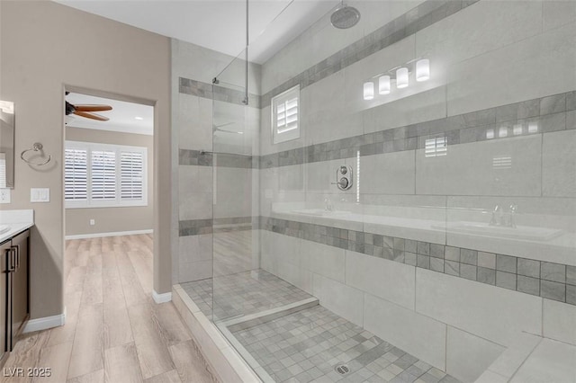 bathroom with ceiling fan, tiled shower, vanity, and hardwood / wood-style floors