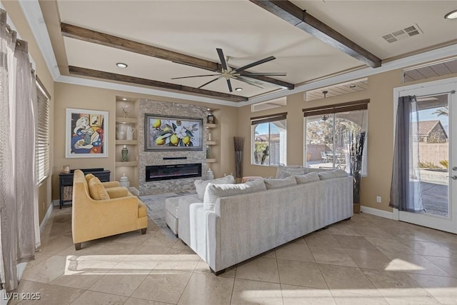 tiled living room with beamed ceiling, plenty of natural light, ceiling fan, and built in shelves