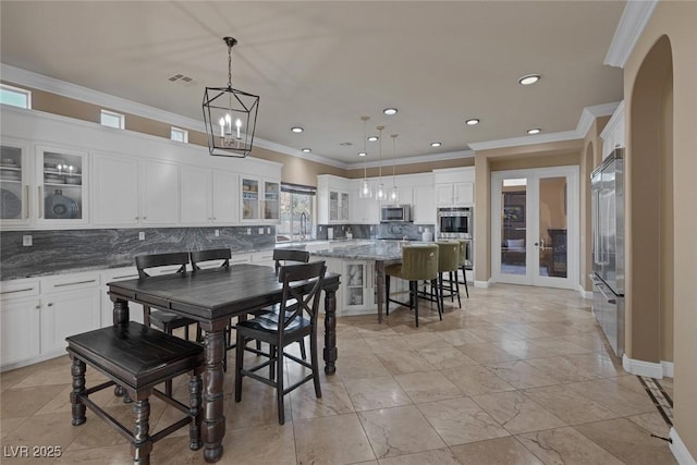 dining room with sink, crown molding, and a notable chandelier