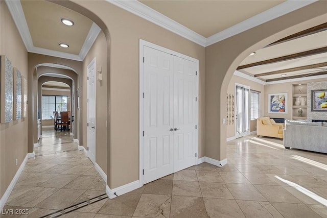 foyer entrance featuring ornamental molding, a wealth of natural light, and beam ceiling