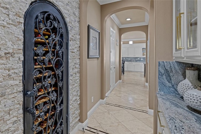 wine area featuring crown molding and light tile patterned flooring