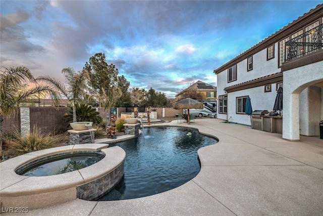 pool at dusk featuring a patio, area for grilling, grilling area, pool water feature, and an in ground hot tub