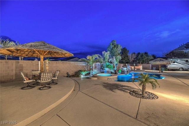 pool at dusk featuring a gazebo, a patio, and an in ground hot tub