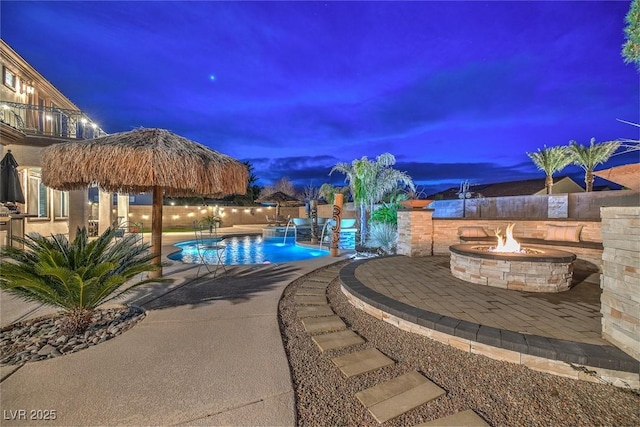 pool at dusk with a patio, a gazebo, and a fire pit