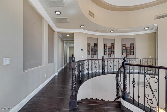 stairway with wood-type flooring and ornamental molding