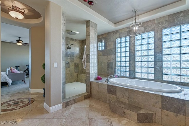 bathroom with decorative columns, shower with separate bathtub, a tray ceiling, ceiling fan, and tile patterned flooring