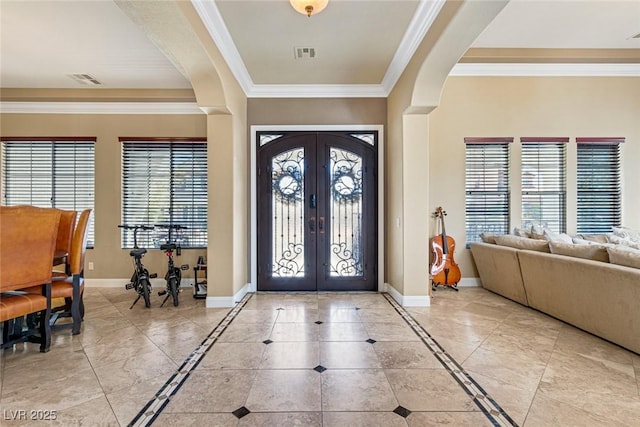 entryway with french doors, ornamental molding, and plenty of natural light