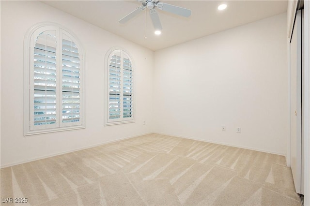 spare room with light colored carpet and ceiling fan