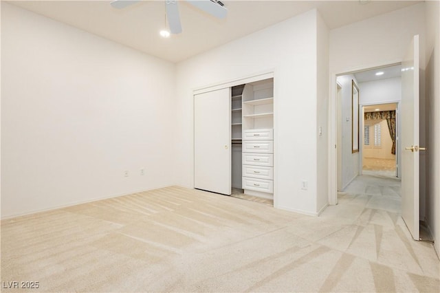 unfurnished bedroom featuring ceiling fan, light colored carpet, and a closet