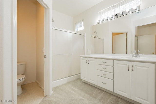 bathroom featuring vanity, a shower with door, and toilet