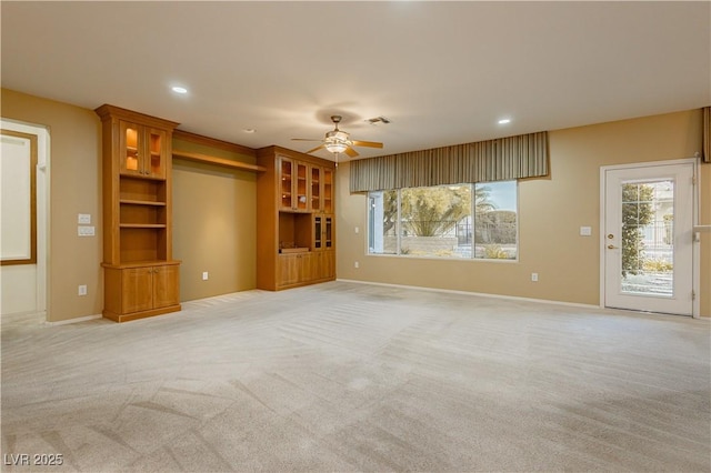 unfurnished living room featuring ceiling fan and light colored carpet