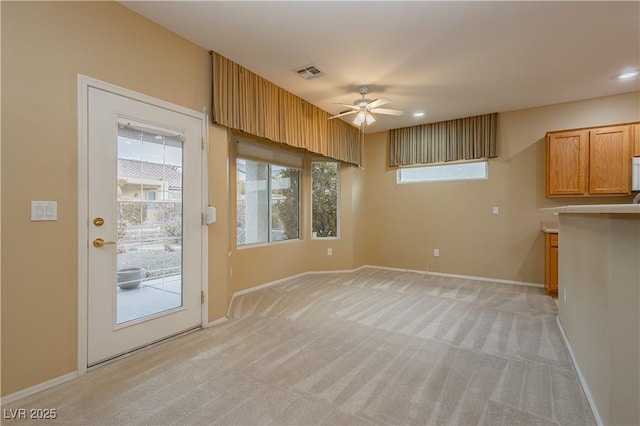 interior space with light carpet and ceiling fan