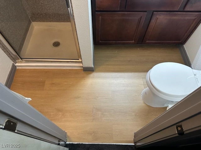 bathroom with hardwood / wood-style flooring and toilet