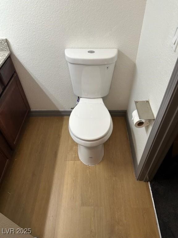 bathroom with vanity, hardwood / wood-style floors, and toilet