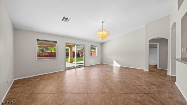 tiled empty room featuring a notable chandelier