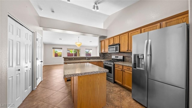 kitchen featuring a breakfast bar, a center island, hanging light fixtures, appliances with stainless steel finishes, and backsplash