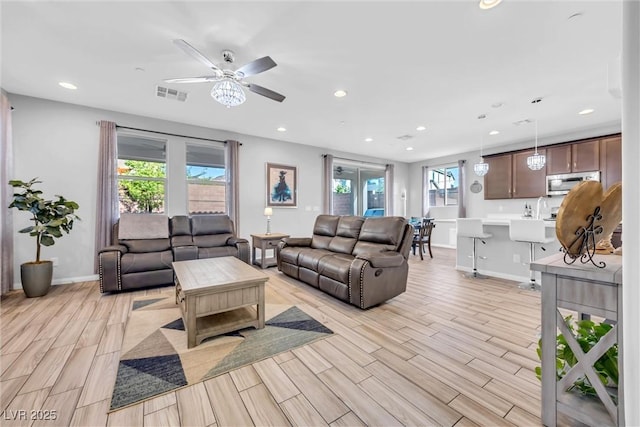 living room featuring sink and ceiling fan