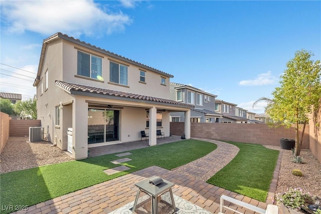 back of house with central AC, a patio, ceiling fan, and a lawn