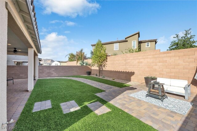 view of yard with ceiling fan and a patio