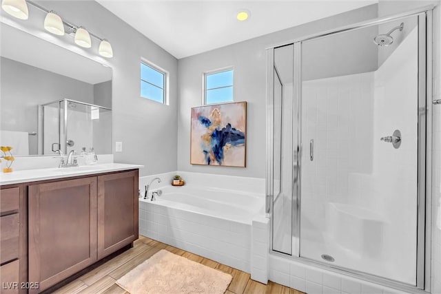 bathroom with independent shower and bath, wood-type flooring, and vanity