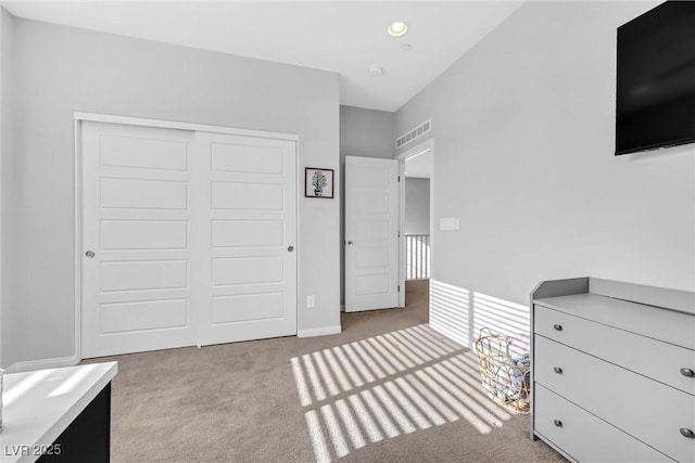 unfurnished bedroom featuring light colored carpet and a closet