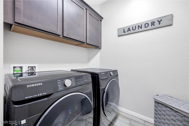 washroom with cabinets and washing machine and clothes dryer