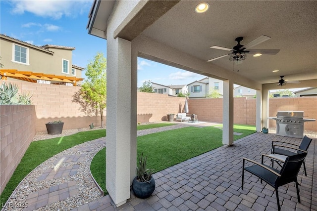 view of patio with ceiling fan and a grill