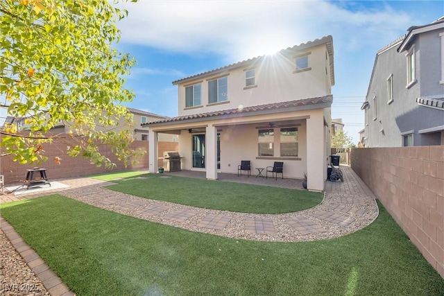 back of house featuring a lawn and a patio area