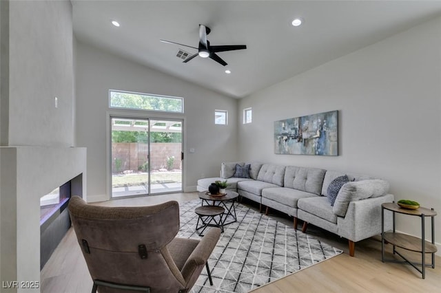 living room with ceiling fan, high vaulted ceiling, and light hardwood / wood-style flooring