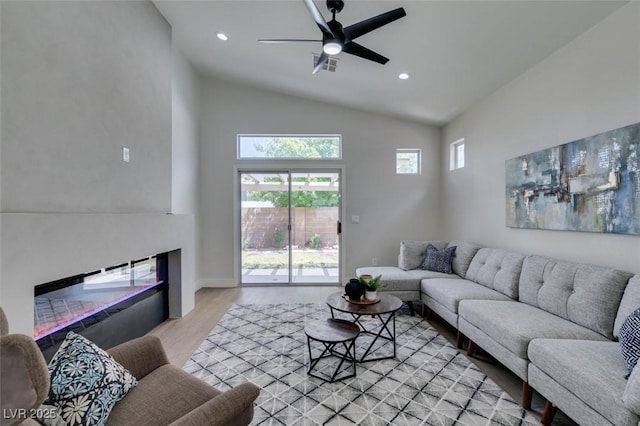 living room with lofted ceiling, light hardwood / wood-style flooring, and ceiling fan