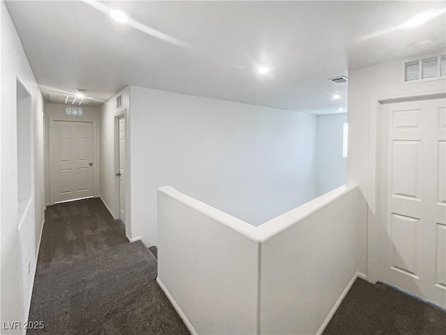 hallway with dark colored carpet