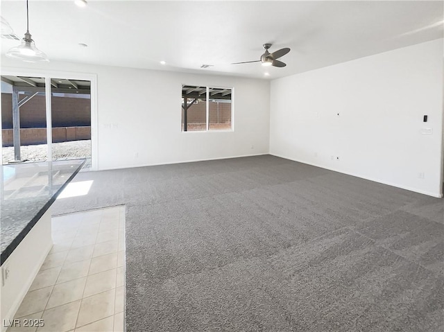 carpeted spare room featuring ceiling fan