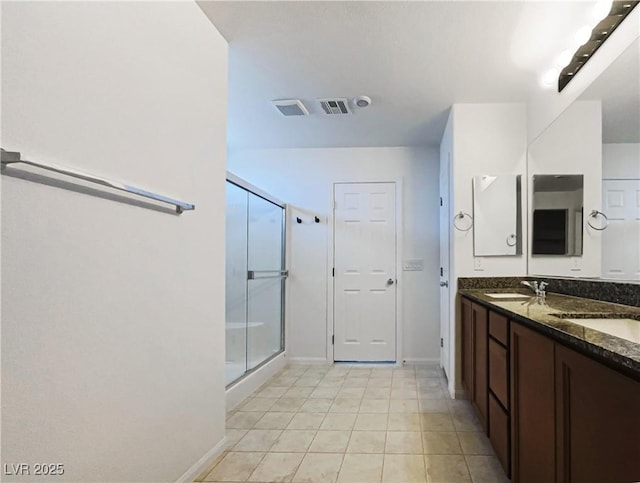 bathroom featuring vanity, tile patterned floors, and walk in shower