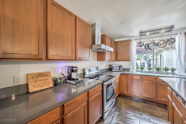 kitchen with wall chimney exhaust hood, stainless steel appliances, and sink