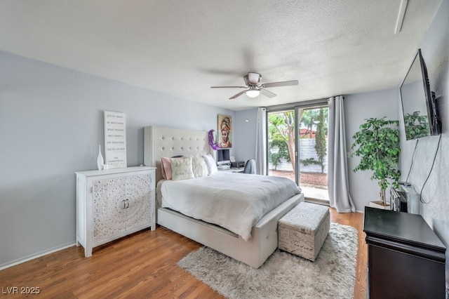 bedroom with hardwood / wood-style floors, ceiling fan, access to outside, and a textured ceiling