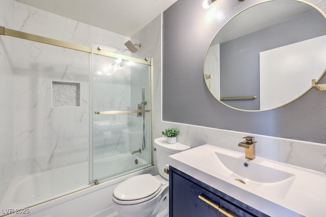 full bathroom featuring vanity, shower / bath combination with glass door, and toilet