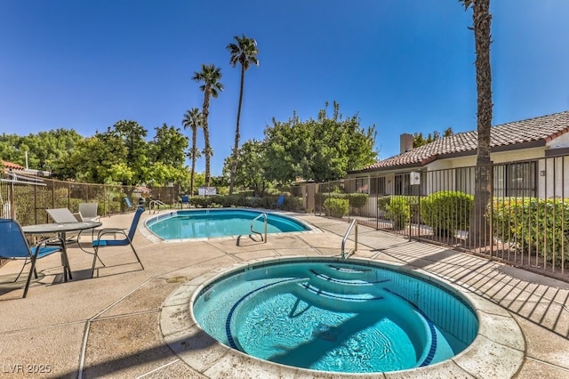 view of swimming pool with a hot tub and a patio area