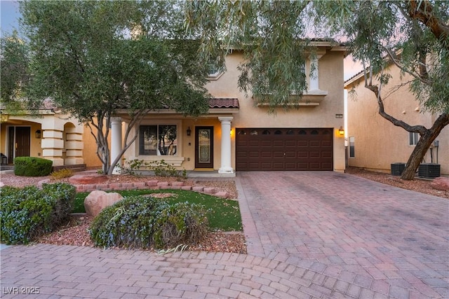 mediterranean / spanish home featuring central AC unit and a garage